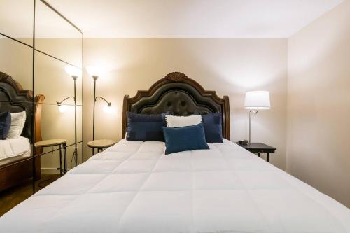 een slaapkamer met een groot wit bed met blauwe kussens bij Sj Elite Loft Sleek Sophistication in San Jose