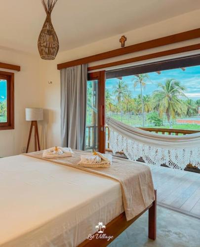 a bedroom with a bed and a large window at Let Village in Amontada
