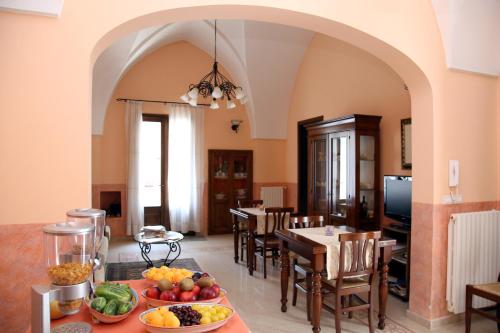una cucina e una sala da pranzo con tavolo e frutta e verdura di B&B Borgosolare a Specchia