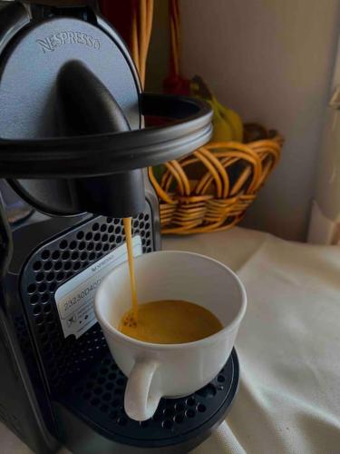 a coffee being poured into a cup in a coffee maker at Ground floor apartment with gym & yard in Paggaio in Próti