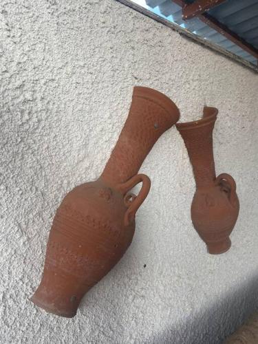 two vases sitting on the side of a wall at Ground floor apartment with gym & yard in Paggaio in Próti