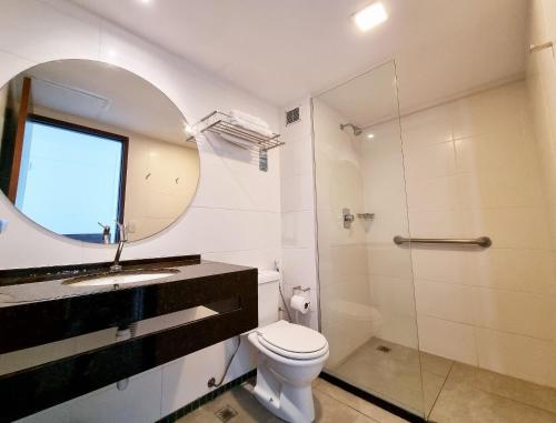 a bathroom with a toilet and a sink and a mirror at Flat Frente Mar + Limpeza | R601 in Maceió