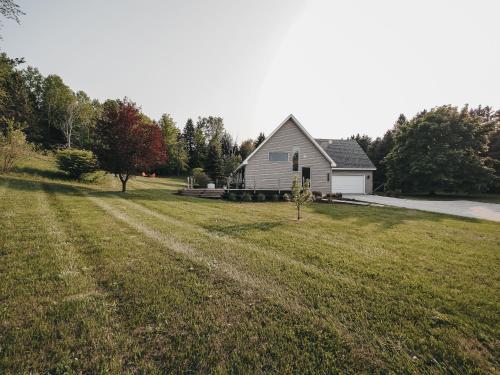 a large yard with a house in the background at Modern Retreat near Traverse City in Cedar