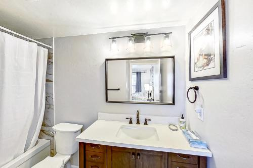 ein Badezimmer mit einem Waschbecken, einem WC und einem Spiegel in der Unterkunft Sunray Meadows 1109 in Steamboat Springs