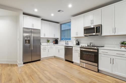 a kitchen with white cabinets and stainless steel appliances at The Eleanor New Orleans in New Orleans
