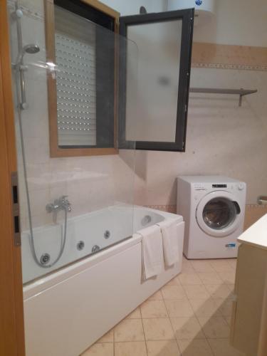 a bathroom with a tub and a washing machine at ARISTOCASA in Lecce