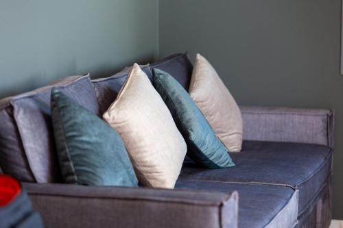 a couch with several pillows on it at Marina Apartments in Kardamili