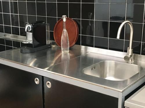 eine Küchentheke mit einer Spüle und einer Flasche Wasser in der Unterkunft Casa Pedra do Sal in Estoril