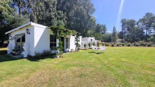 una casa blanca con dos sillas en un patio en Bella Vista, en Underberg