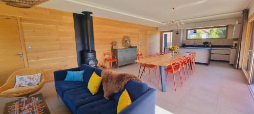 - un salon avec un canapé bleu et un poêle à bois dans l'établissement La Renouée, à Gérardmer