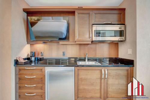 a kitchen with a sink and a microwave at MGM Signature-38-617 Top floor F1 View Balcony in Las Vegas