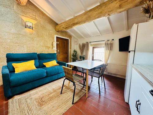 a living room with a blue couch and a table at La Bohème : Gardon et Pont Du Gard in Remoulins