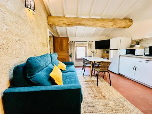 a living room with a blue couch and a kitchen at La Bohème : Gardon et Pont Du Gard in Remoulins