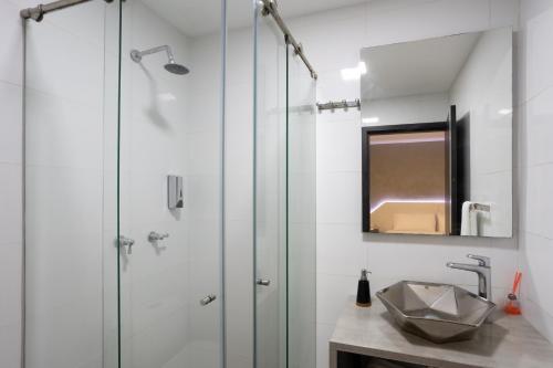 a bathroom with a glass shower and a sink at Prixma Hotel in San Andrés