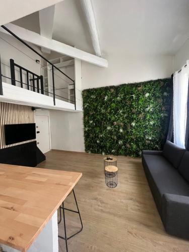 a living room with a couch and a green wall at Charmant Duplex centre de nimes in Nîmes