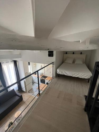 um pequeno quarto com uma cama e uma varanda em Duplex avec Clim centre de nimes em Nîmes