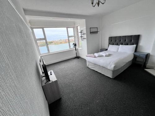 a bedroom with a bed and a large window at Harbour Flats in Skegness