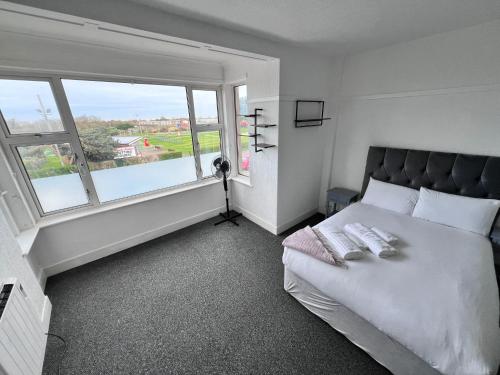 ein Schlafzimmer mit einem Bett und einem großen Fenster in der Unterkunft Harbour Flats in Skegness