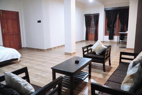 - un salon avec un lit, une table et des chaises dans l'établissement ROYALTY GLOBAL HOMESTAY, à Shillong