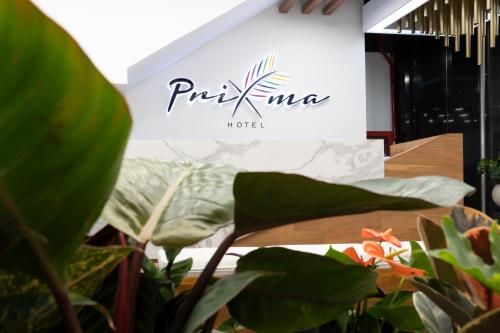 a sign for a hotel with plants in the foreground at Prixma Hotel in San Andrés
