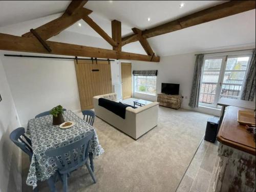 a living room with a table and a couch at Evelith Manor Barns in Shifnal