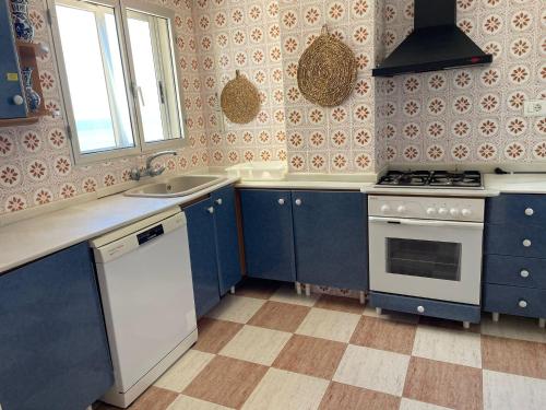 cocina con armarios azules, fregadero y fogones en Apartamento con Vistas Panorámicas, en Sueca