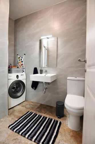 a bathroom with a sink and a washing machine at Ġarra Farmhouse with Heated Pool in Għasri