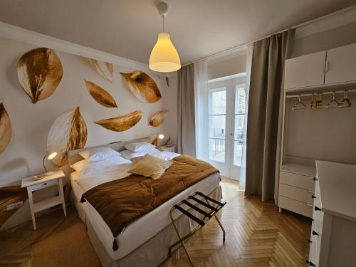 een slaapkamer met een bed met bladeren aan de muur bij Golden Flat by GrazRentals with parkview - brandnew & free parking in Graz