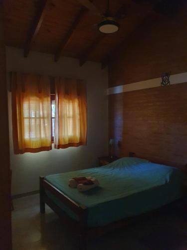 a bedroom with a bed and a window at El Aguaribay de los Nonos in Mina Clavero
