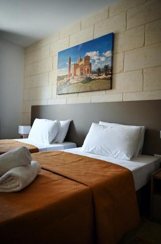 two beds sitting next to each other in a room at Ġarra Farmhouse with Heated Pool in Għasri