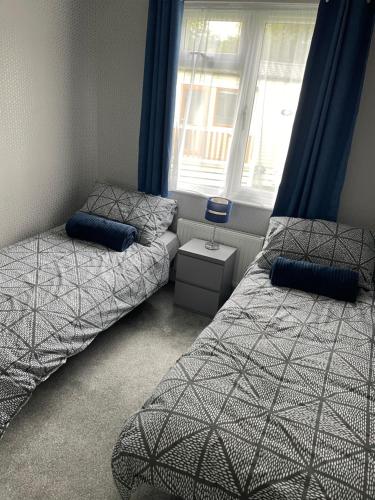 1 dormitorio con 2 camas y ventana en Quince, en Ferndown
