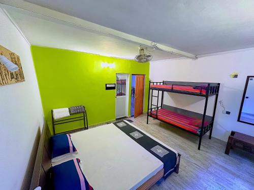 a room with two bunk beds and a green wall at PLACE 236 in Kandy