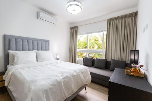 1 dormitorio con 1 cama blanca grande y 1 sofá en Villa At Metro Country Club With Private Pool en San Pedro de Macorís