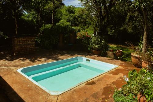 una piscina azul en un patio en Thathe Dam Lodge, en Vhutandabos