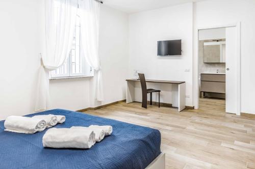 a bedroom with a blue bed with towels on it at La Perla Rooms in Saronno