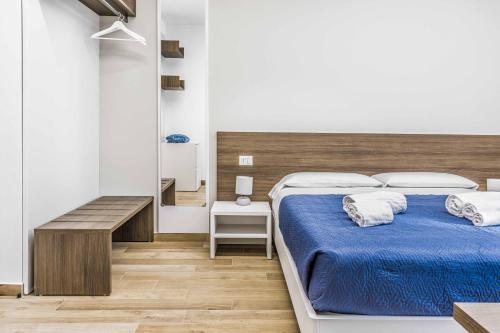 a bedroom with a bed with blue sheets and white pillows at La Perla Rooms in Saronno