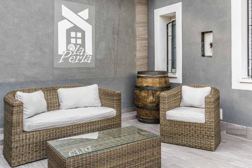 two wicker chairs and a table and a barrel at La Perla Rooms in Saronno