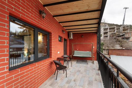 a balcony with chairs and a table on a brick building at Honeymoon Apartments in Old Tbilisi in Tbilisi City