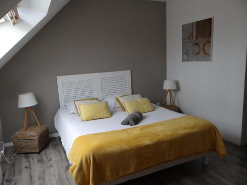 a bedroom with a bed with yellow sheets and two lamps at gite la fécampoise près de Fécamp in Ganzeville