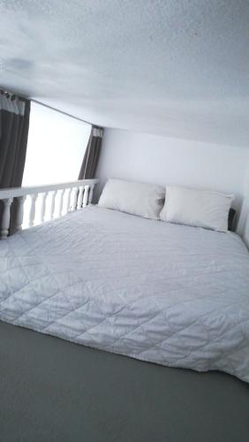 a white bed in a room with a window at The Best in Perissa