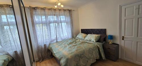 a bedroom with a bed and a window at Avala, 5/6 Bed House in Romford in Great Warley Street