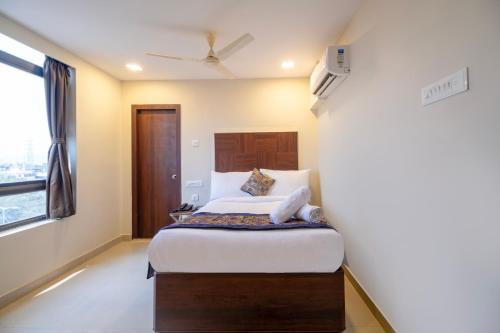 a bedroom with a bed and a window at Monday Hotels Swarna's The Capital in Vijayawāda