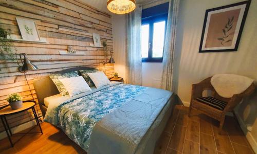 une chambre avec un lit et un mur en bois dans l'établissement Le Clos du Mesnielle, à Ochancourt