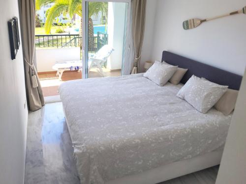 a bedroom with a bed and a view of a balcony at Casa Sol Calahonda in Sitio de Calahonda