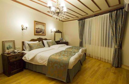 Oba Hotel في إسطنبول: غرفة نوم بسرير كبير وثريا