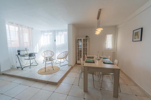 un salon avec une table et des chaises dans l'établissement Les Salins * Appartement * Clim * Wifi * Commerces, à Fos-sur-Mer