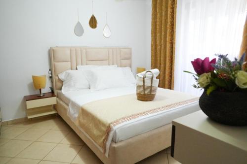 a bedroom with a bed with a basket of flowers at SHANO'S Apartment - Free Parking in Sarandë