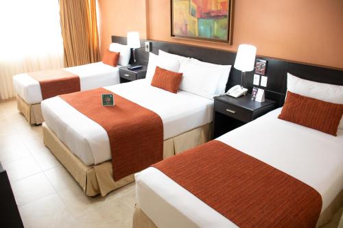a hotel room with three beds in a room at Hotel Arizona Suites Cúcuta in Cúcuta