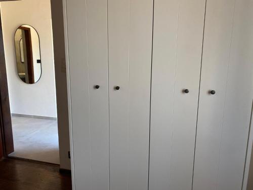 a row of white cabinets in a room with a mirror at Apartments Hortenzija in Maslinica
