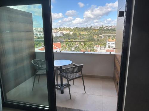 a balcony with a table and chairs and a view at AP Maria Nova Lounge - Adults Friendly in Tavira